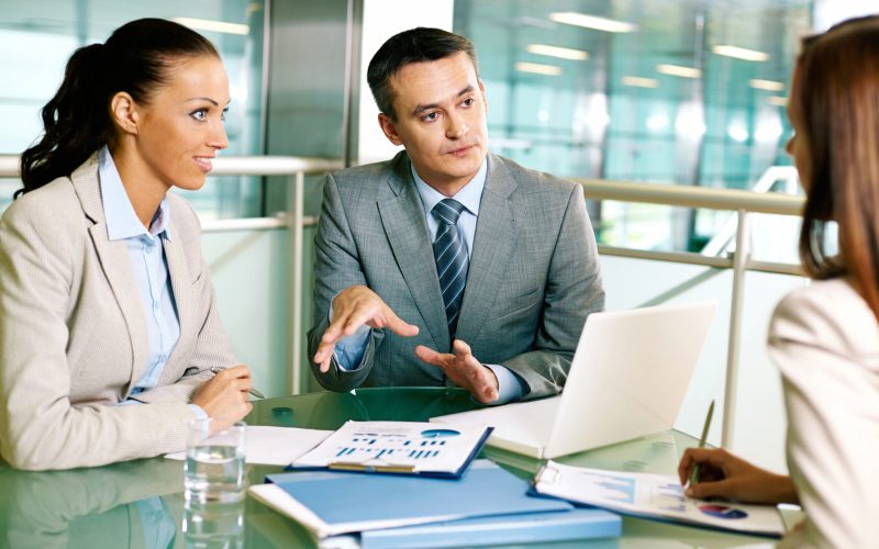 Group of business partners interacting at meeting in office