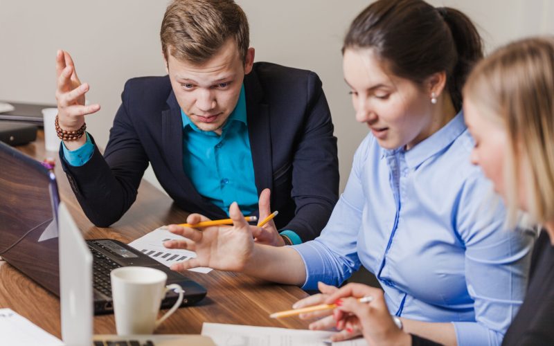 office-employees-sitting-desk-talking