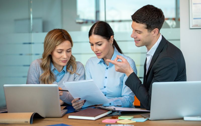 Three confidence business people discussing contract together in the office